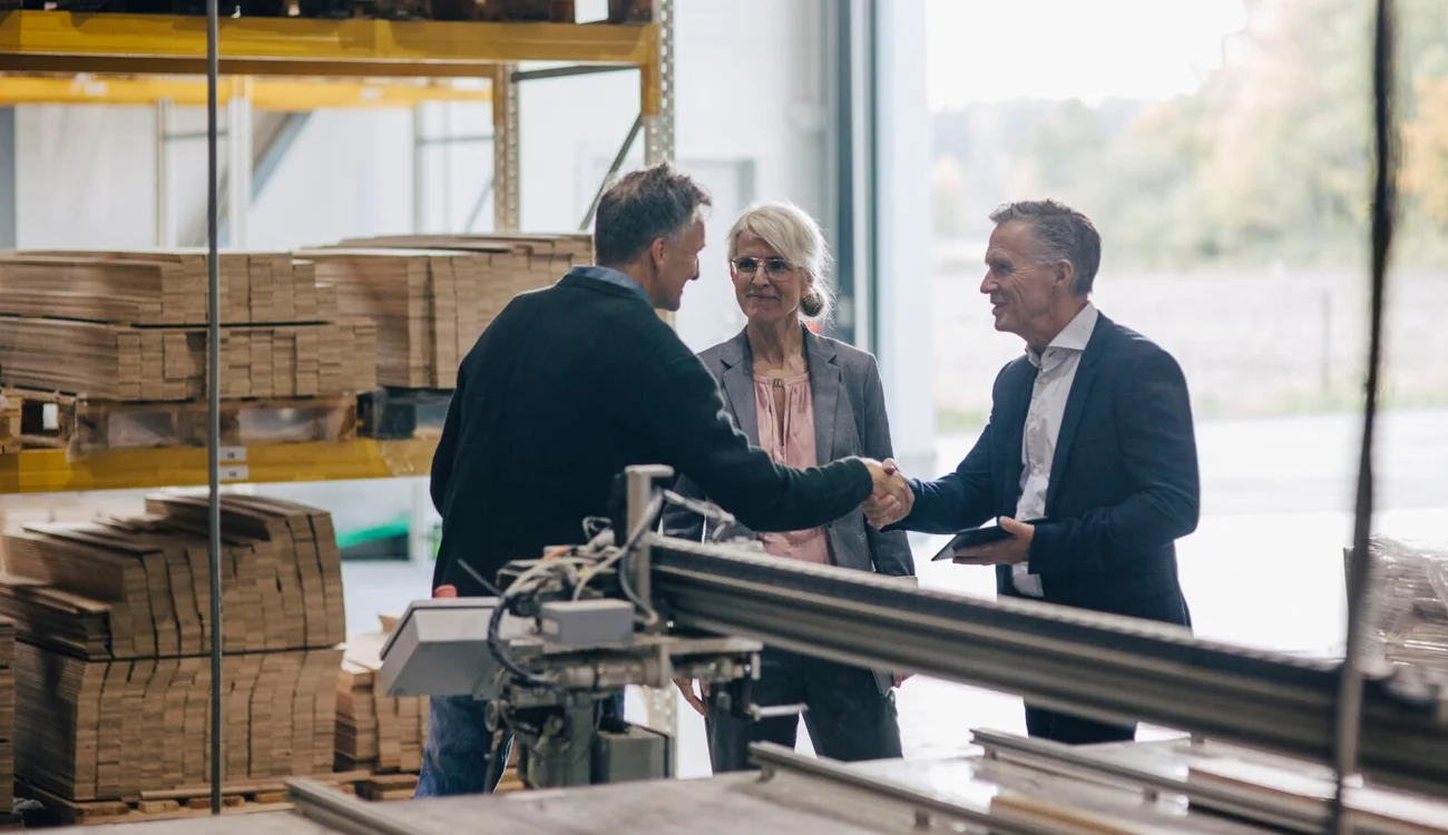 People shaking hands in carpentry workshop
