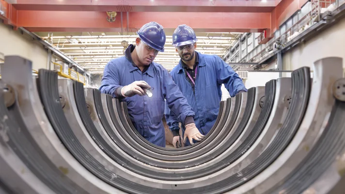Two men manufacturing a tube